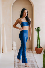 Woman in blue athletic wear standing in a room with a cactus plant.