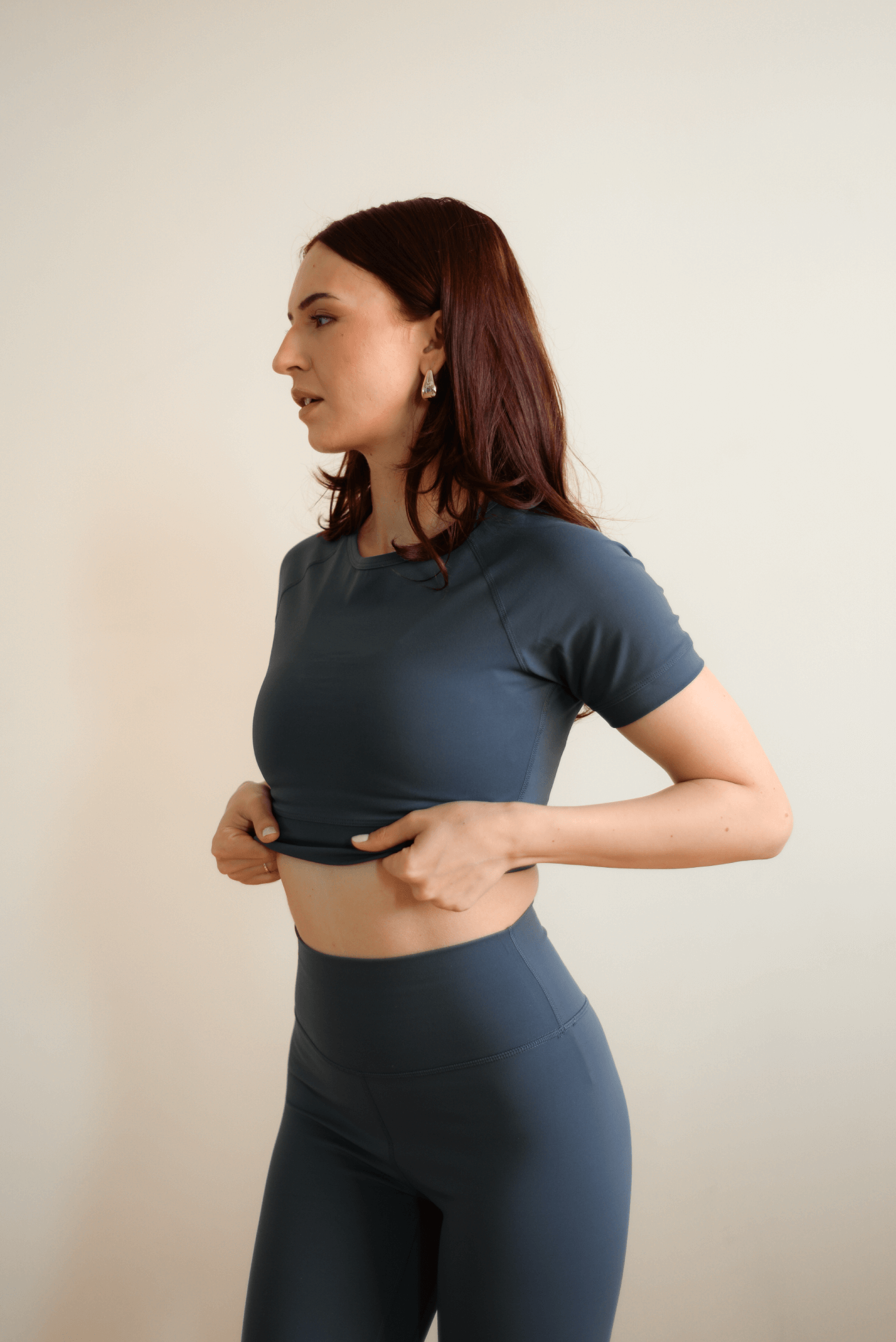 Woman wearing a dark blue athletic outfit against a plain background